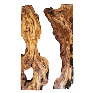 Puede incluir: Dos losas de madera de forma irregular con borde natural. La veta de la madera presenta una mezcla de tonos marrones claros y oscuros, con nudos y patrones visibles. Una losa tiene un agujero grande. El fondo es blanco.