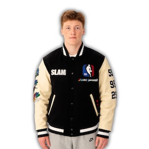 May include: Black and cream-colored varsity jacket with the word "SLAM" on the chest. The jacket features the NBA logo and "NBC peacock" branding. The sleeves display the numbers "59", "99", and "25".