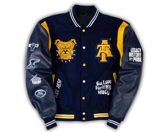 May include: A navy blue varsity jacket with yellow accents and dark blue sleeves. The front features a bulldog patch, an AT logo, and text reading EST. 1891 and Got Love For My HBCU. The sleeves have patches including a fist, shoe, drum, and football.