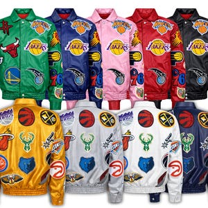 Puede incluir: Una colección de chaquetas bomber de satén en varios colores, incluyendo verde, azul, rosa, rojo, amarillo, blanco y negro. Cada chaqueta presenta parches con logotipos de equipos y un cierre de botones. Las chaquetas se muestran tanto por delante como por detrás.