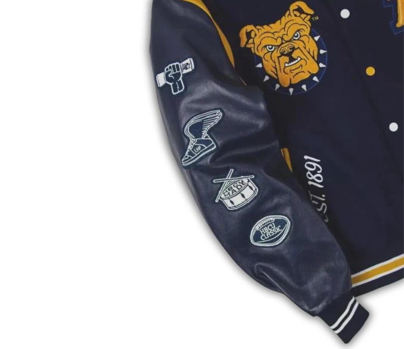 May include: Navy blue varsity jacket with yellow and white accents. Features a bulldog patch and various embroidered patches on the sleeve. The jacket has the text "EST. 1891" on the right side.