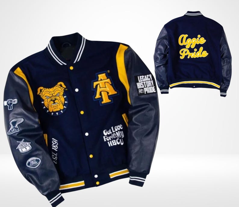May include: Navy blue and yellow varsity jacket with leather sleeves. Features a bulldog graphic, the letters "A" and "T", and the words "Aggie Pride" on the back. Includes patches with text and symbols. The jacket has a striped collar, cuffs, and hem.