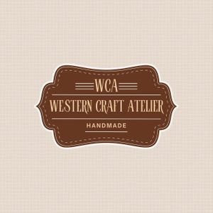 May include: A brown and white logo with the text "WCA" above "WESTERN CRAFT ATELIER" and "HANDMADE". The logo is in a decorative shape with a stitched border, set against a beige textured background.