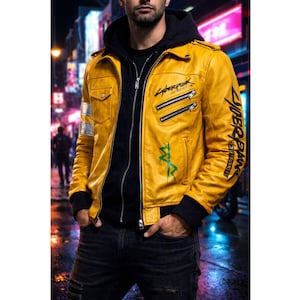 May include: A yellow leather jacket with black accents, featuring the text "Cyberpunk" and other graphics. The jacket has a zip-up front, multiple pockets, and silver stripes on the sleeves. The person is wearing a black hoodie underneath.