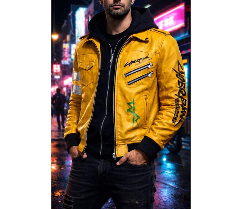 May include: A yellow leather jacket with black accents, featuring the text "Cyberpunk" and other graphics. The jacket has a zip-up front, multiple pockets, and silver stripes on the sleeves. The person is wearing a black hoodie underneath.