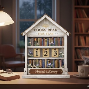 May include: A white wooden bookshelf-shaped decor piece with the text "BOOKS READ THIS YEAR" and "Amanda's Library". It features miniature books, floral accents, and number tiles 1, 2, and 3. A cozy library theme.