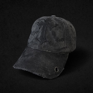 Könnte beinhalten: Eine verwaschene schwarze Baseballkappe mit einem markanten gestickten Kreuz auf der Vorderseite, dezenten Fledermaus-Silhouetten, einer dünnen Zierkordel am Schirmansatz und einer einzelnen Metallöse an der Seite des gebogenen Schirms.