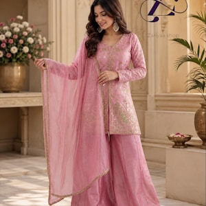 May include: A light pink three-piece ensemble featuring a long-sleeved tunic with a V-neckline, gold embroidery, and sequin embellishments. The outfit includes wide-leg trousers and a matching sheer dupatta with a gold-trimmed border.
