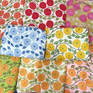 May include: A collection of floral patterned fabric squares in various colors. The designs include orange, red, yellow, pink, and blue flowers with green vines on a white background. The fabrics are arranged in a visually appealing display.