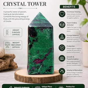 Puede incluir: Una torre de cristal de rubí zoisita con inclusiones minerales de color verde oscuro y magenta. La piedra se muestra sobre una base de madera circular. El texto en la imagen incluye Ruby Zoisite Crystal Tower, 5 inches, 900 gram.
