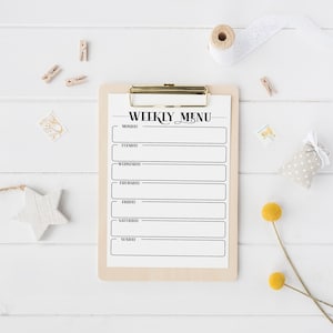 May include: A white weekly menu planner on a clipboard with a gold clip. The planner has blank lines for each day of the week, Monday through Sunday.