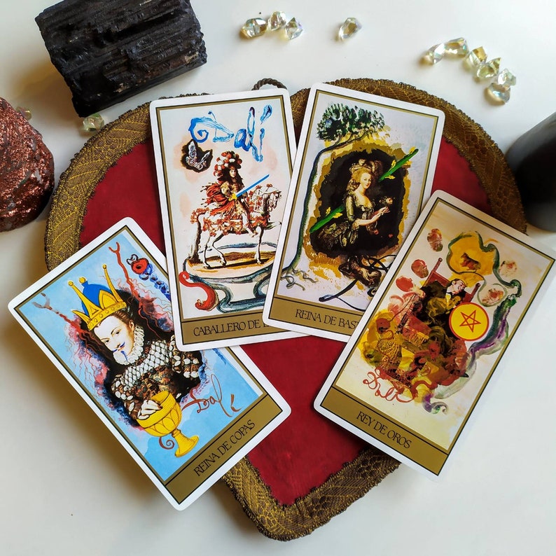 Puede incluir: Cuatro cartas de tarot con ilustraciones coloridas y texto en espa&ntilde;ol. Las cartas son "Caballero de Bastos", "Reina de Bastos", "Rey de Oros", y "Reina de Copas".