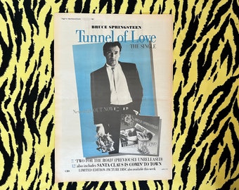 Könnte beinhalten: Ein Schwarzweißfoto von Bruce Springsteen, der einen Strauß weißer Blumen hält. Das Foto stammt aus einer Zeitungsanzeige für seine Single "Tunnel of Love". Die Anzeige enthält auch den Text "New single OUT NOW" und "7: TWO FOR THE ROAD (PREVIOUSLY UNRELEASED) 12: also includes SANTA CLAUS IS COMIN' TO TOWN LIMITED EDITION PICTURE DISC also available this week."