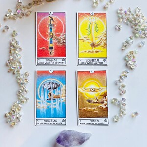 Peut inclure: Quatre cartes de tarot avec des illustrations et du texte color&eacute;s. Les cartes sont l'As de B&acirc;tons, l'As d'&Eacute;p&eacute;es, l'As de Coupes et l'As de Deniers. Chaque carte a une image et un texte diff&eacute;rents en allemand et en anglais.
