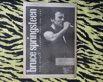 Könnte beinhalten: Ein Schwarzweißfoto von Bruce Springsteen, einem Musiker, auf einem Magazincover. Der Text auf dem Cover lautet "Bruce Springsteen" und "neue Single - härter als der Rest".