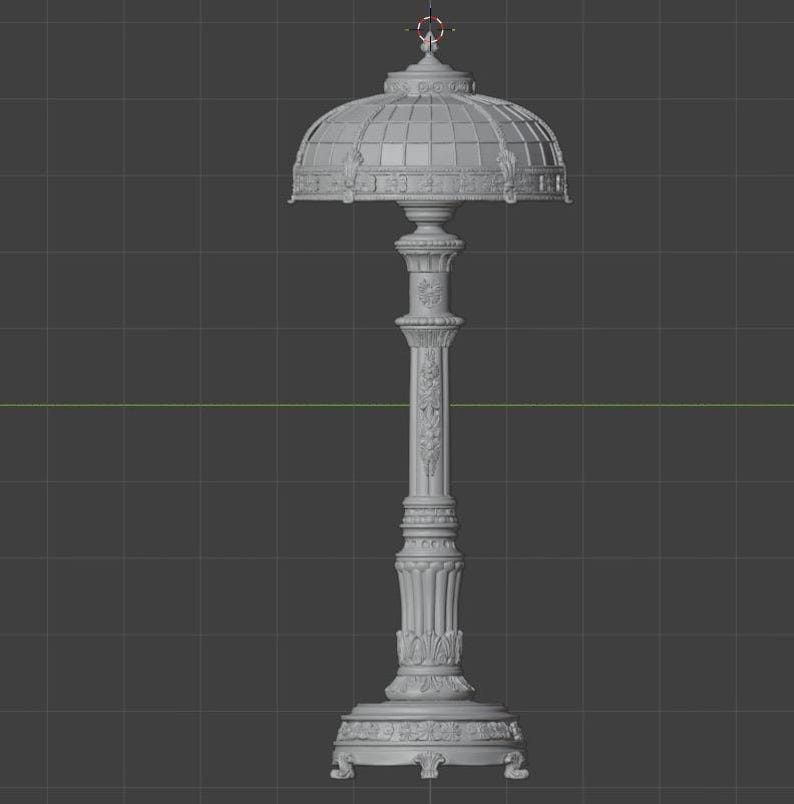 May include: A grey 3D digital model of a table lamp featuring a dome-shaped shade with a grid pattern and a decorative column base. The lamp has an ornate, textured surface with floral and geometric relief details throughout the structure.