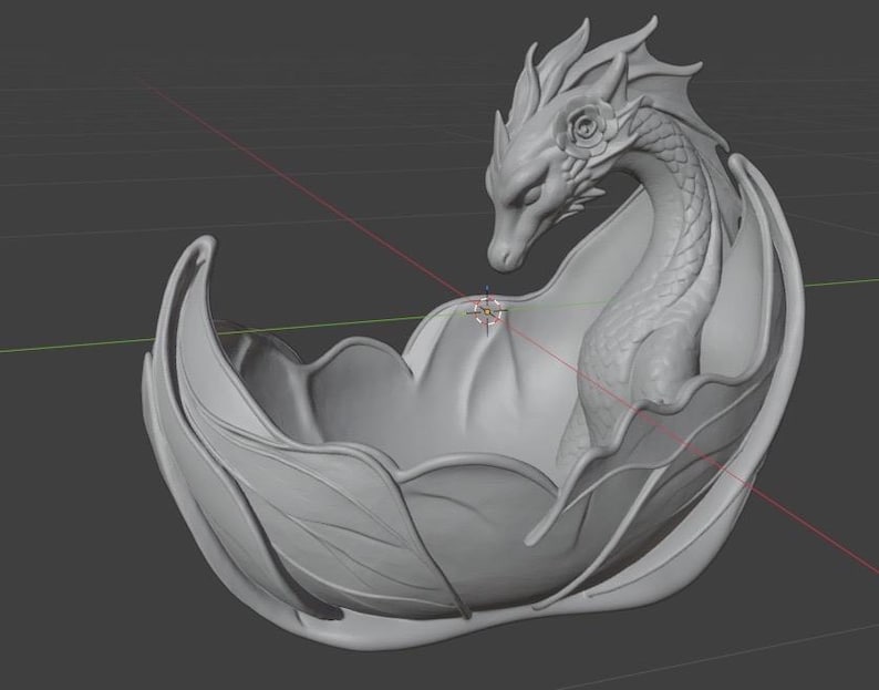 Pu&ograve; includere: Una scultura di drago grigio, renderizzata in 3D, all'interno di una ciotola a forma di foglia stilizzata. Il drago presenta squame dettagliate, ali e un ornamento a forma di rosa. I bordi della ciotola si incurvano con grazia.