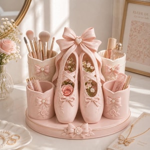 May include: A pink ballerina shoe-shaped vanity organiser with a matching tray. The organiser features multiple compartments for makeup brushes, perfume, and other beauty products. The shoes are decorated with bows and filled with flowers.