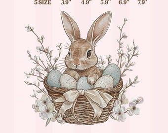 May include: An embroidery design for machine featuring a brown bunny in a woven basket filled with speckled blue eggs. The basket has a cream-colored bow. The design includes the text "EMBROIDERY DESIGN FOR MACHINE" and size options from 3.9" to 7.9".