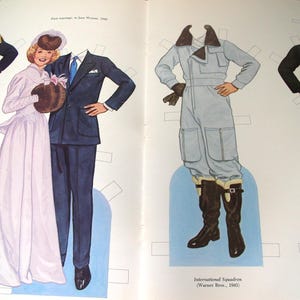 May include: A vintage paper doll set featuring illustrated figures and various outfits including a military uniform, a wedding gown, a dark suit, a light blue flight jumpsuit with a fur-lined collar, and a dark coat with brown trousers and boots.