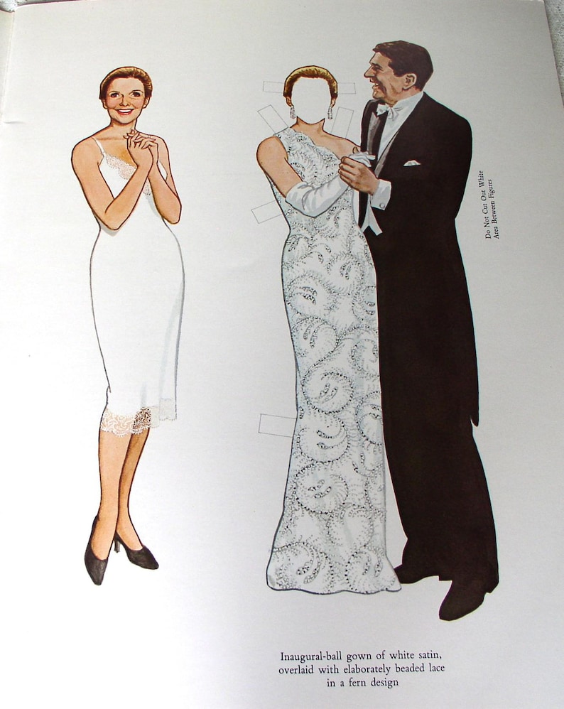 May include: A paper doll set featuring a figure in a white slip dress and a figure in a white beaded lace gown with a fern design, paired with a figure in a black tuxedo. Text reads: Inaugural-ball gown of white satin, overlaid with elaborately beaded lace in a fern design. Do Not Cut Out White Area Between Figures.