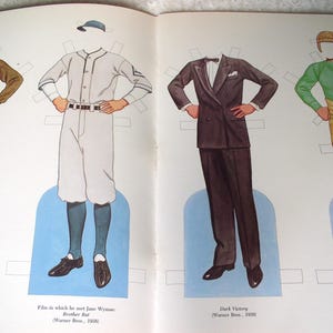 May include: A vintage paper doll set featuring four figures with blank faces. The outfits include a brown military uniform, a white baseball uniform with a cap, a dark double-breasted suit with a bowtie, and a green long-sleeve shirt with tan breeches.