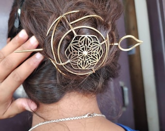 Puede incluir: Accesorio para el cabello dorado, con un diseño circular y un centro floral, además de un pasador largo. El accesorio está colocado en cabello castaño oscuro. Diseñado para sujetar el cabello.