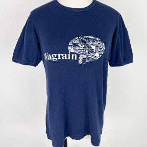 May include: A navy blue t-shirt with a white graphic of a town and the text "Wagraim".