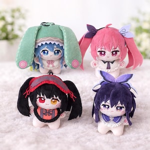 Puede incluir: Cuatro muñecos de peluche de estilo anime. Cada muñeco tiene un peinado y una combinación de colores únicos, incluyendo rosa, azul, negro y morado. Los muñecos tienen rasgos faciales detallados y llevan accesorios decorativos.
