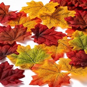 May include: A collection of colorful artificial maple leaves in shades of red, orange, yellow, and green. The leaves have detailed veining and are scattered, creating a fall or autumn theme.