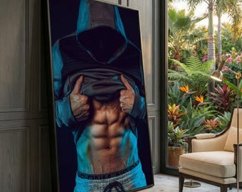 May include: Framed print showing a person in a grey hoodie, lifting their shirt to reveal defined abdominal muscles. The image has a dark background with blue lighting, and the person is wearing grey sweatpants. The print is displayed in a room with a window overlooking a garden.