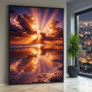 Könnte beinhalten: Gerahmter Leinwanddruck eines Sonnenuntergangs am Strand. Das Bild zeigt einen leuchtend orangefarbenen und gelben Sonnenuntergang mit Lichtstrahlen, die durch die Wolken brechen und sich im Wasser spiegeln. Das Kunstwerk wird in einem modernen Innenraum gezeigt.