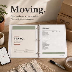 Puede incluir: Un archivador blanco abierto con la palabra "Moving" impresa en la portada y las páginas interiores. Contiene una lista de verificación del presupuesto de mudanza y espacio para notas. Se ve un smartphone con una aplicación de calendario.