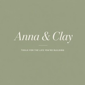 May include: A sage green background with the words "Anna & Clay" in a delicate, off-white script font. Below, the text reads "TOOLS FOR THE LIFE YOU'RE BUILDING" in a smaller, sans-serif font.