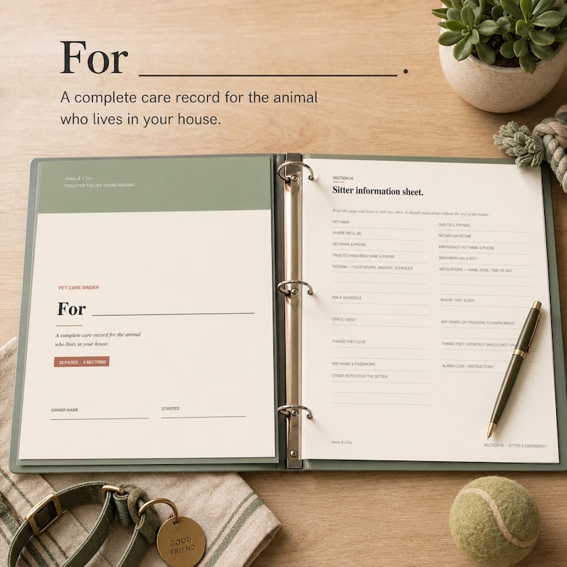 May include: Open binder with pet care record pages. The cover reads "For: A complete care record for the animal who lives in your house." Includes a pen, tennis ball, and a dog collar with a "Good Friend" tag.
