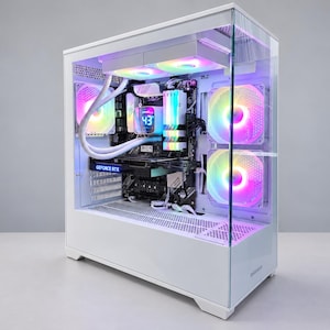 Puede incluir: Una torre de ordenador blanca con panel lateral de cristal, que incluye componentes internos con iluminación RGB multicolor, un sistema de refrigeración líquida con pantalla digital de temperatura que muestra 43 y una tarjeta gráfica GeForce RTX.