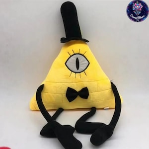 Könnte beinhalten: Ein gelbes, dreieckiges Plüschtier mit schwarzem Zylinder, Fliege und schwarzen Gliedmaßen. Das Spielzeug zeigt ein einzelnes Auge und ist eine Figur aus einer beliebten Zeichentrickserie.