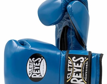 May include: A pair of vibrant blue boxing gloves. The gloves feature the "CLETO REYES" logo in white and black on the wrist and a black and gold label. The gloves are made in Mexico and are designed for professional use.