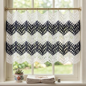 May include: A white and dark navy blue chevron patterned crochet valance curtain hanging on a brass rod. The curtain features an openwork stitch design with alternating horizontal stripes of white and dark navy blue yarn in a zigzag pattern.