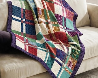 May include: A patchwork quilt featuring a grid of multicolored fabric squares in shades of red, blue, green, purple, and cream. The quilt is finished with a dark purple border featuring a repeating geometric pattern and intricate stitching.