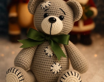 May include: A handmade gray crochet teddy bear with a green bow, white accents, and black stitching. The bear has a stitched patch design and is sitting in a snowy scene with a reindeer and Santa Claus in the background.