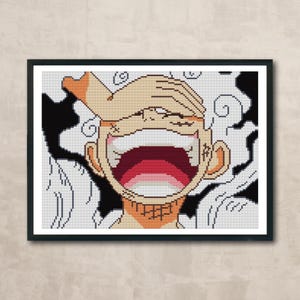May include: Cross-stitch art of a character with a wide open mouth and a hand covering the eyes. The character's skin is tan, with a red and pink mouth. The background features black and white swirls, all within a black frame.