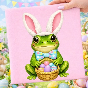 Puede incluir: Una impresión en lienzo rosa con una rana de dibujos animados con orejas de conejo y una pajarita azul. La rana sostiene una cesta llena de coloridos huevos de Pascua. El fondo incluye un área de césped y decoraciones de Pascua.