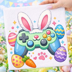 Puede incluir: Toalla cuadrada blanca con un diseño de dibujos animados de un mando de videojuegos con orejas de conejo, huevos de Pascua, una zanahoria y una huella de pata. El mando es verde claro y azul con botones coloridos. Temática de Pascua.