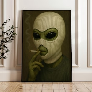 Könnte beinhalten: Gerahmtes Kunstwerk mit einer Alien-Figur, die eine weiße Skimaske trägt und eine Zigarette raucht. Der Außerirdische hat große schwarze Augen und grüne Haut. Das Kunstwerk ist vor einem gedämpften Hintergrund.