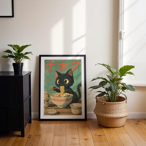 May include: A framed poster featuring a black cat eating ramen noodles. The poster has Japanese text and a green background. The cat is depicted with large eyes and is holding chopsticks. The poster is displayed on a wooden floor next to a black cabinet and a potted plant.