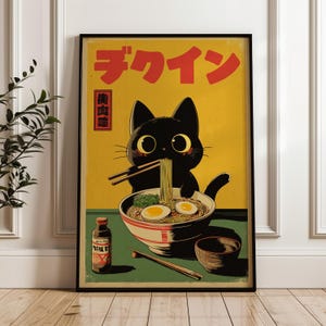 Könnte beinhalten: Gerahmter Kunstdruck mit einer schwarzen Katze, die Ramen isst. Das Bild zeigt japanischen Text in Rot und einen Vintage-Stil. Die Katze hat große Augen und hält Essstäbchen, während sie Nudeln aus einer Schüssel isst. Der Hintergrund ist gelb und grün.