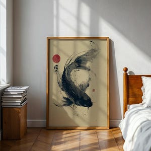 May include: Framed art print featuring a black and white koi fish illustration. The artwork has a minimalist style with Japanese calligraphy and a red sun. The print is displayed in a wooden frame, adding a touch of natural warmth to the room.