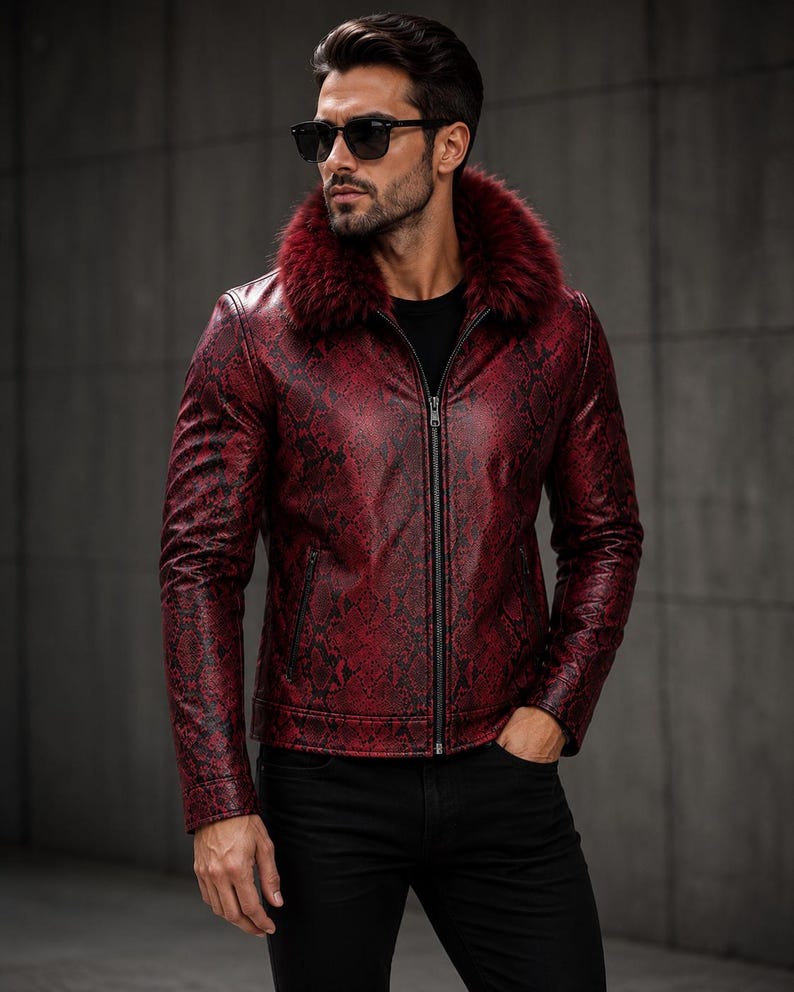 Peut inclure: Une veste &agrave; motif peau de serpent rouge et noir dot&eacute;e d'un col en fausse fourrure rouge fonc&eacute;, d'une fermeture &eacute;clair int&eacute;grale et de manches longues. La veste est port&eacute;e sur un t-shirt noir uni avec un pantalon noir et des lunettes de soleil.