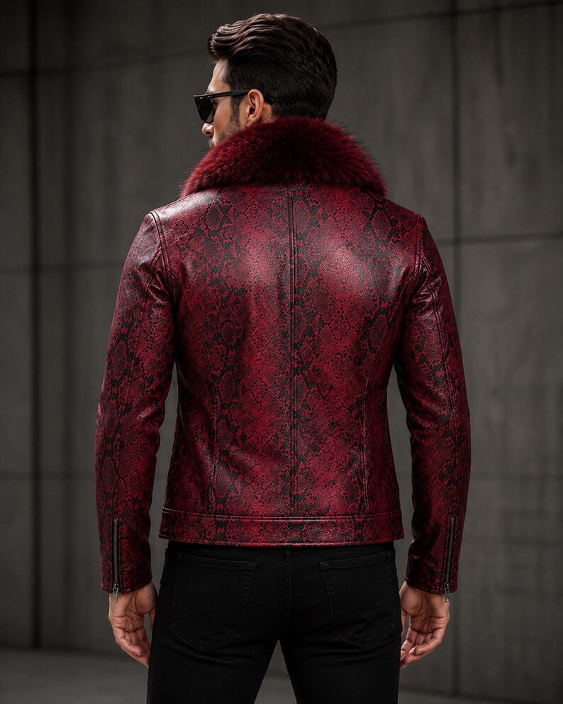 Peut inclure: Une veste rouge fonc&eacute; avec un motif peau de serpent noir sur toute la surface, un col en fausse fourrure rouge fonc&eacute; pro&eacute;minent et des manches longues avec des poignets zipp&eacute;s. La veste est port&eacute;e avec un pantalon noir et des lunettes.